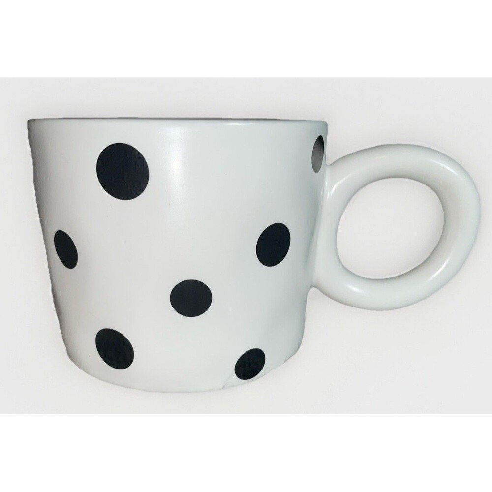 white ceramic mug with black dots and a chunky C-handle